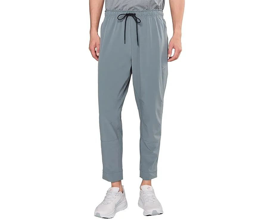 Брюки Nike Unlimited Dri FIT с зауженным кроем и карманами на молнии