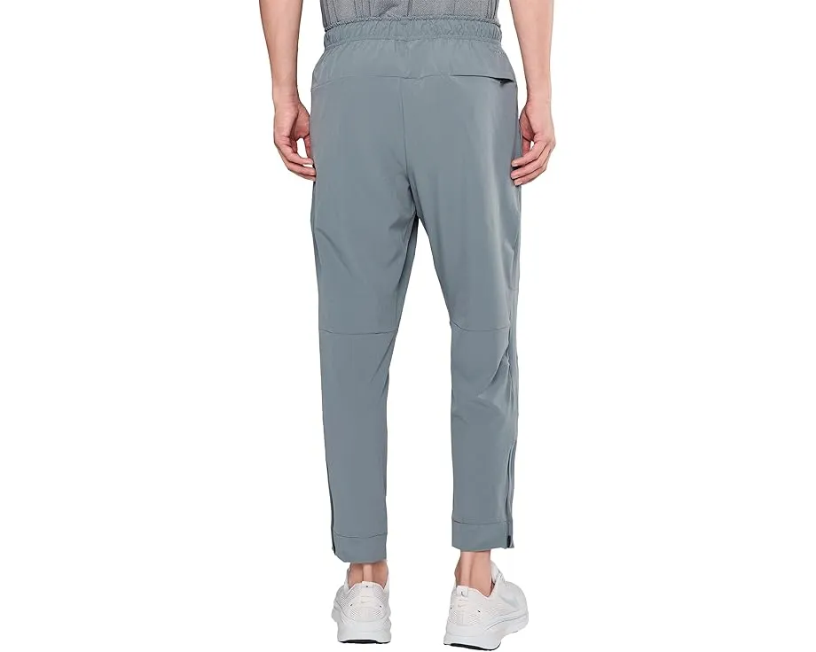 Брюки Nike Unlimited Dri FIT с зауженным кроем и карманами на молнии