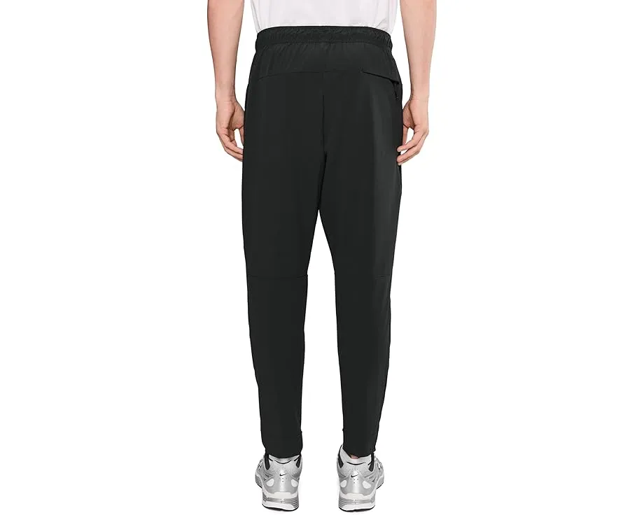 Брюки Nike Unlimited Dri FIT с зауженным кроем и карманами на молнии